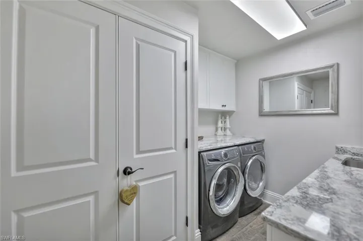 Laundry area featuring independent washer and dryer and cabinet space