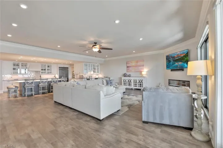 Living room featuring ornamental molding, light wood finished floors, a ceiling fan, and recessed lighting
