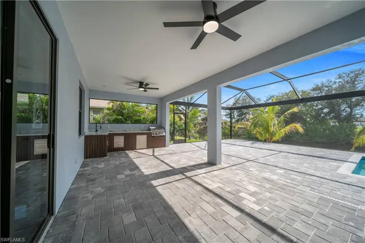 View of patio with a ceiling fan, area for grilling, and a lanai