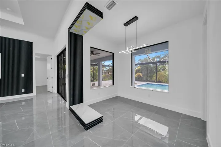 Unfurnished dining area featuring a chandelier, marble finish flooring, and a ceiling fan