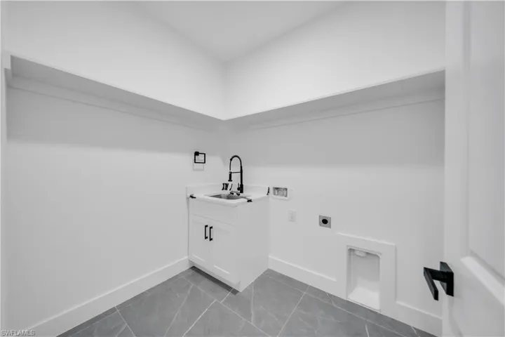 Washroom with hookup for an electric dryer, hookup for a washing machine, and cabinet space