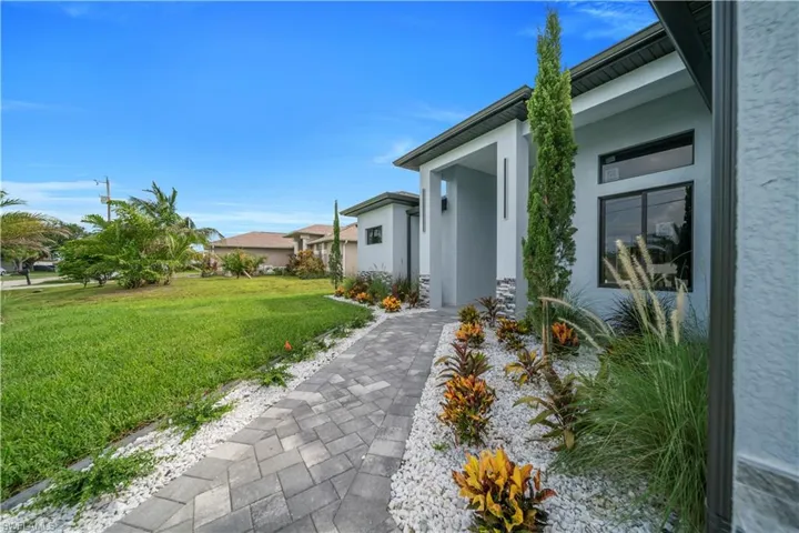 View of side of home with stucco siding and a lawn