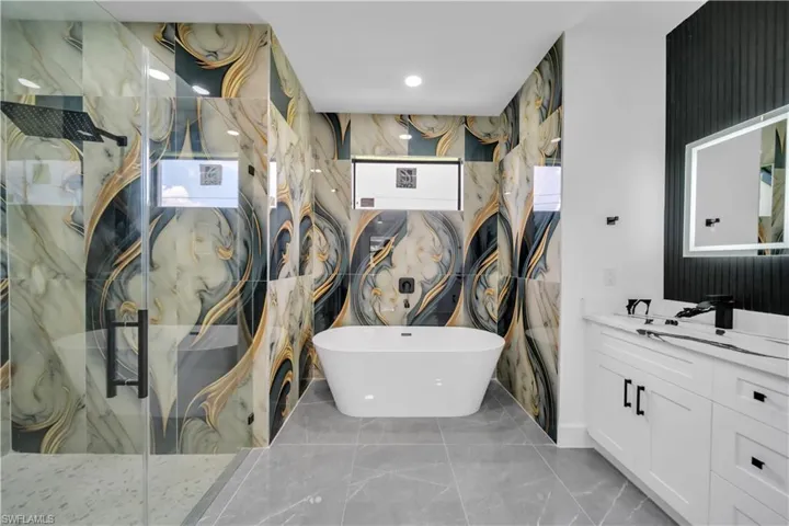 Full bathroom featuring vanity, a marble finish shower, a soaking tub, marble finish floors, and recessed lighting