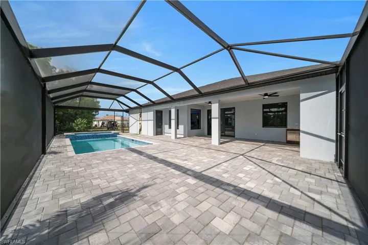 View of pool featuring a ceiling fan, a patio area, a lanai, and a pool with connected hot tub