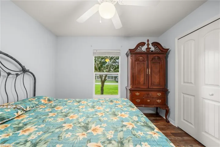 Bedroom featuring dark wood-type flooring, a closet, and a ceiling fan