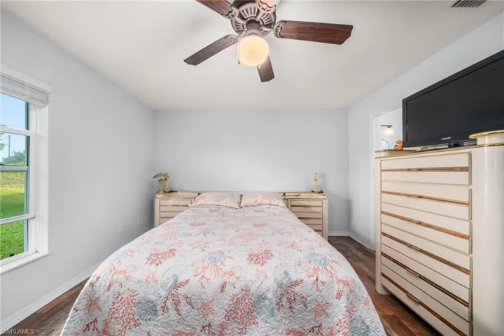Bedroom with a ceiling fan and dark wood-style flooring