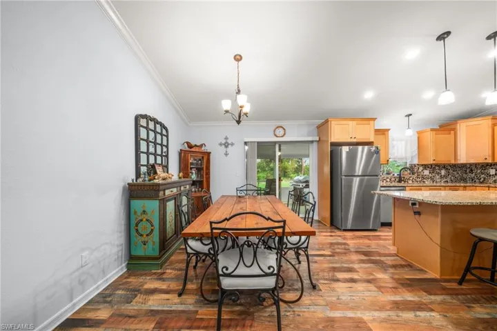 Dining space featuring crown molding, dark wood-style floors, a chandelier, and recessed lighting