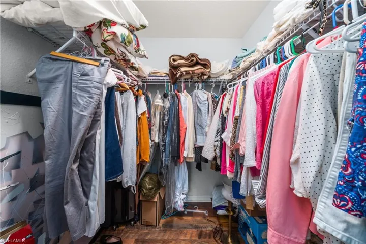 Spacious closet with dark wood-style floors