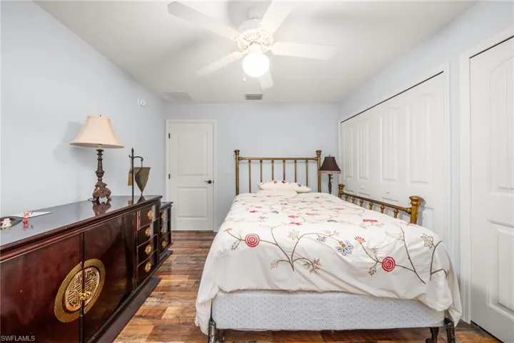 Bedroom featuring dark wood-type flooring, a ceiling fan, and a closet