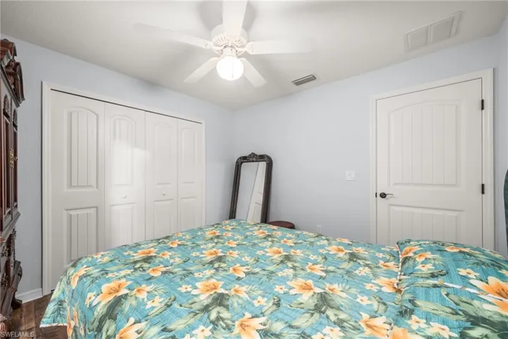 Bedroom featuring ceiling fan, a closet, and dark wood-style floors