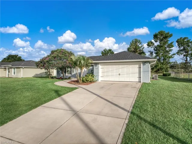 Ranch-style home featuring concrete driveway, an attached garage, and stucco siding