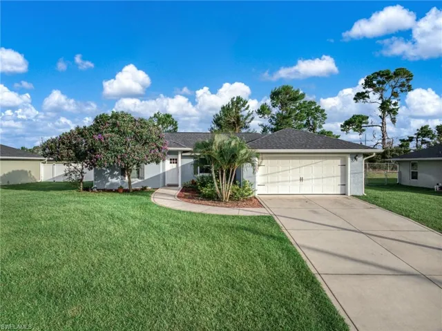 Single story home featuring an attached garage and concrete driveway