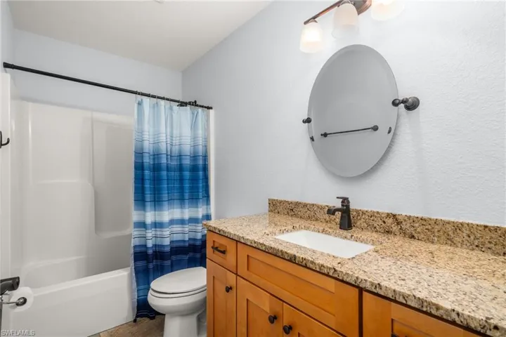 Full bathroom featuring vanity and shower / bathtub combination with curtain