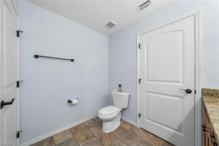 Half bathroom with baseboards and stone finish flooring