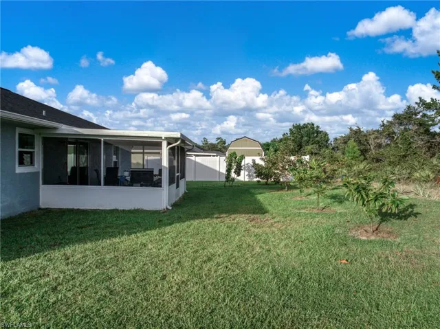 View of green lawn featuring a sunroom
