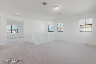 Carpeted spare room featuring baseboards