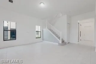 Unfurnished living room featuring stairs