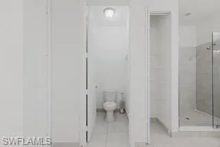 Bathroom featuring a shower stall and light tile patterned floors