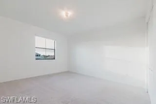 Empty room featuring light carpet