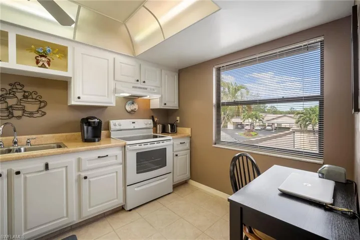Kitchen with white cabinets and white range with electric stovetop