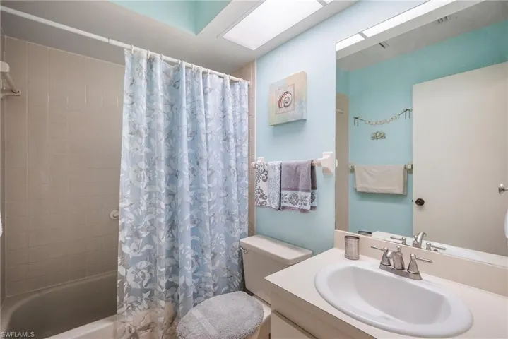 Full bathroom with toilet, vanity, and shower / bath combo