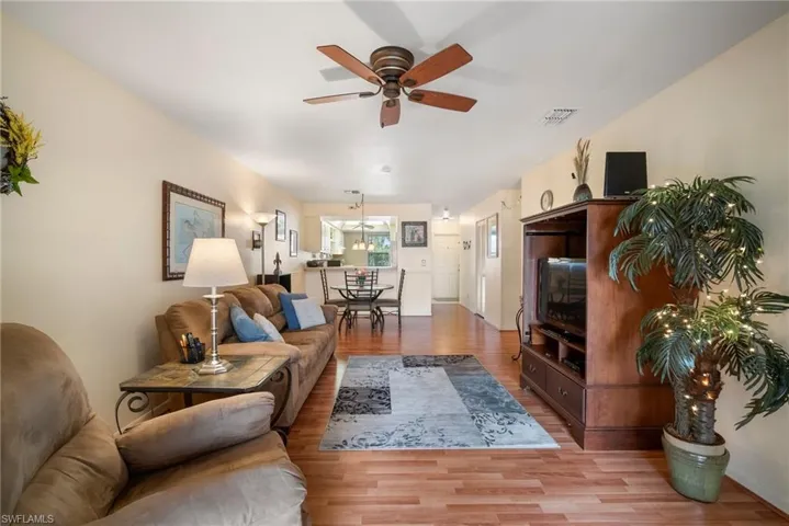 Living room with light wood-type flooring and ceiling fan