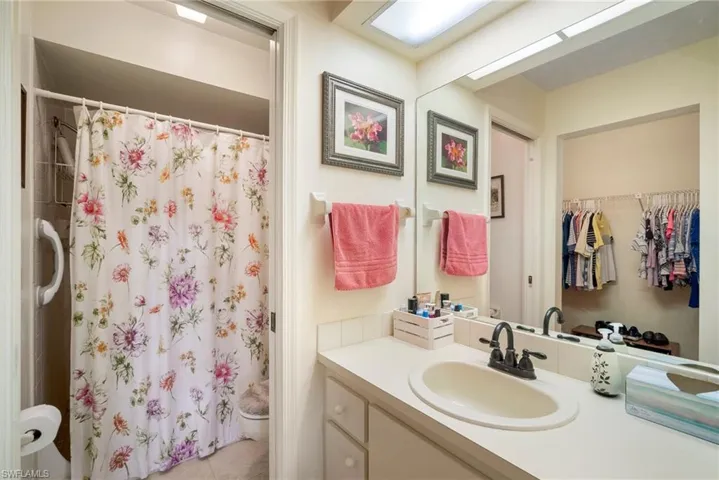 Bathroom featuring a shower with curtain, tile patterned floors, and vanity