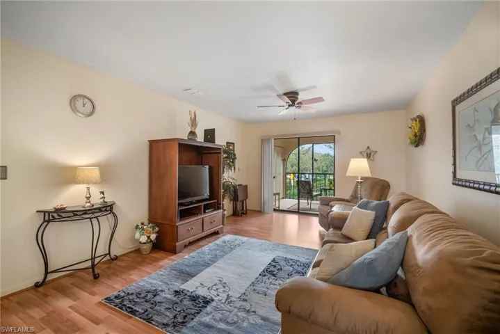 Living room with ceiling fan and light hardwood / wood-style flooring