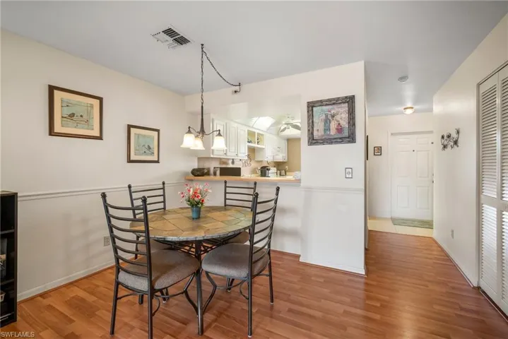 Dining space with ceiling fan with notable chandelier and light hardwood / wood-style floors