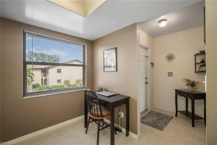 Home office with a healthy amount of sunlight and light tile patterned floors