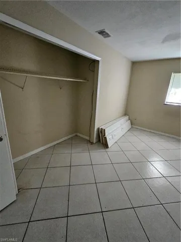 Unfurnished bedroom featuring a closet and light tile patterned floors