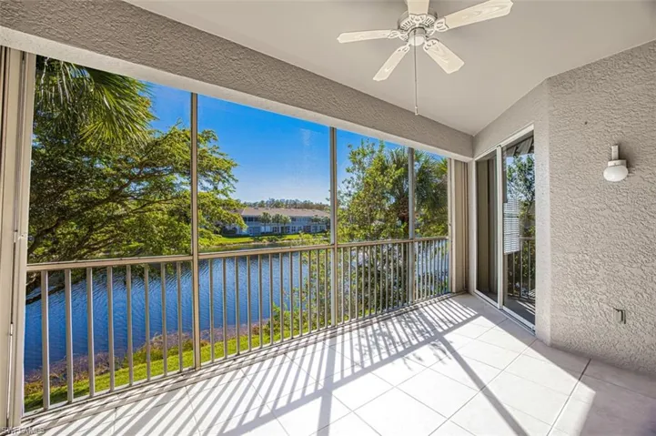 Unfurnished sunroom with a water view, plenty of natural light, and ceiling fan