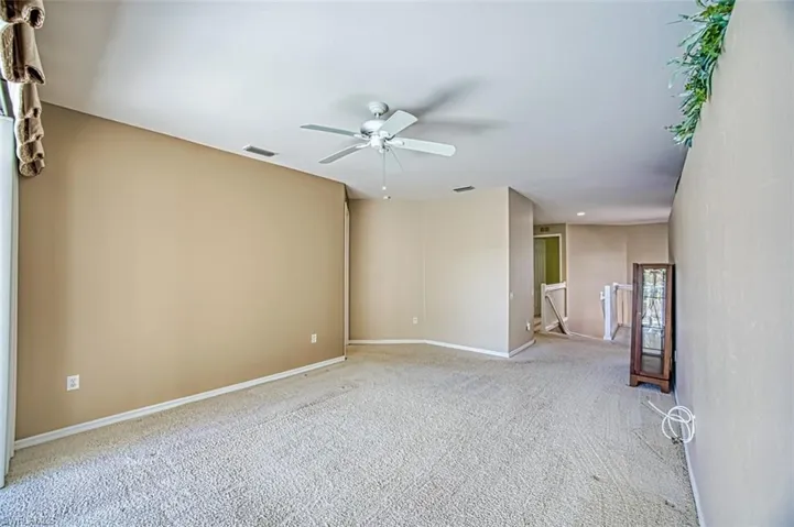 Carpeted empty room with ceiling fan