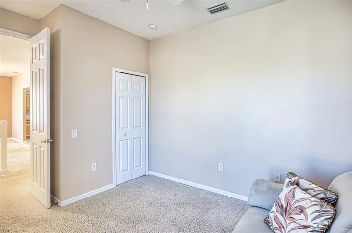 Unfurnished room featuring ceiling fan and carpet