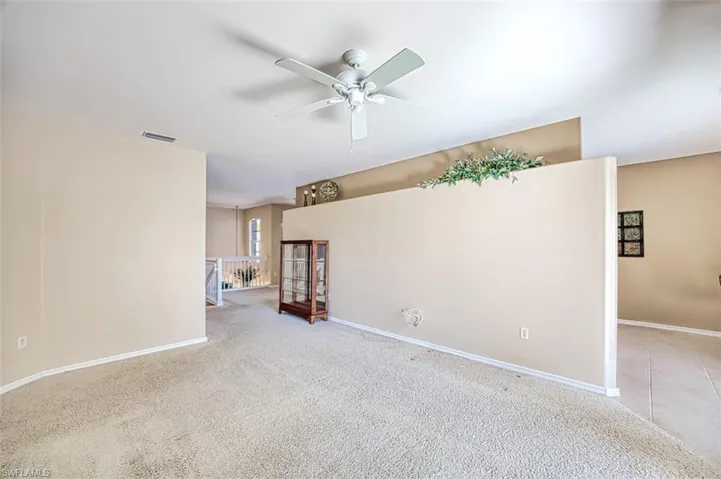 Spare room with ceiling fan and light colored carpet