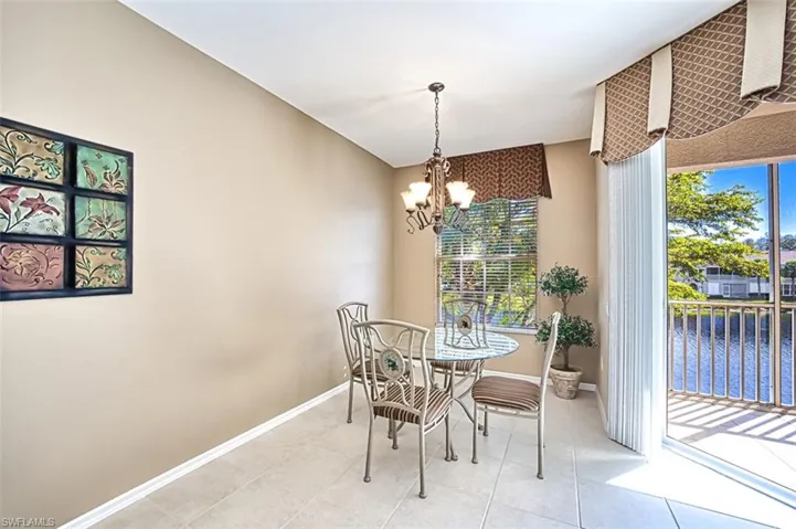 Tiled dining area featuring a water view and an inviting chandelier