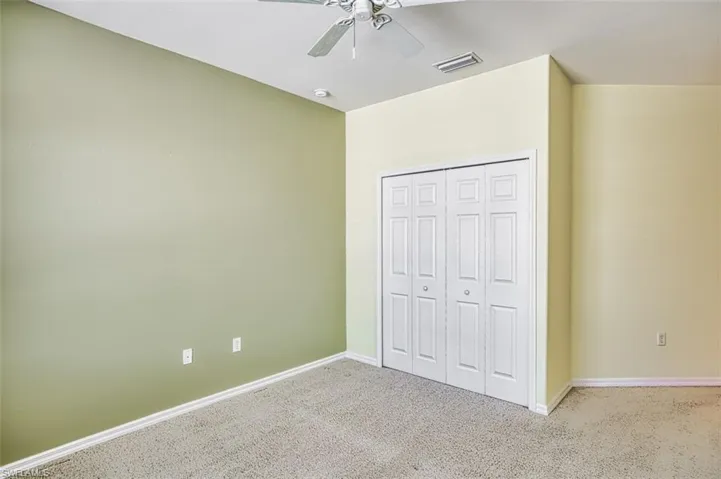 Unfurnished bedroom with carpet flooring, ceiling fan, and a closet