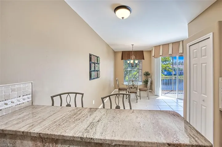 Dining space with light tile patterned floors and an inviting chandelier