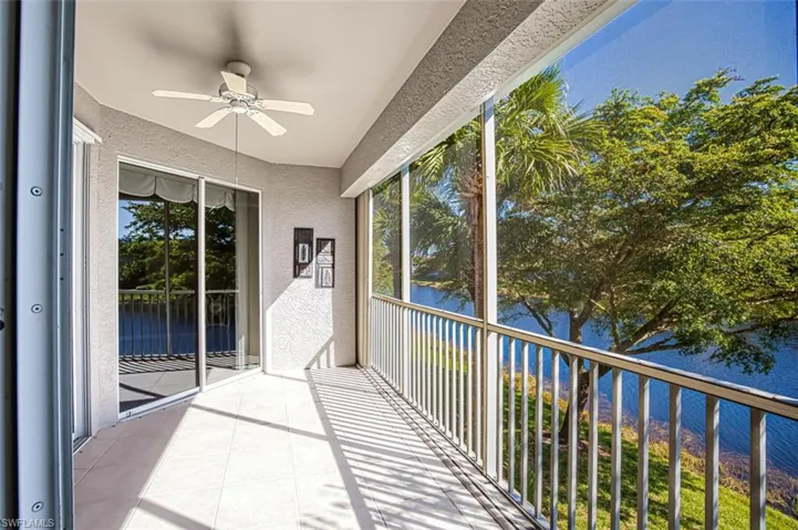 Unfurnished sunroom with ceiling fan and a water view