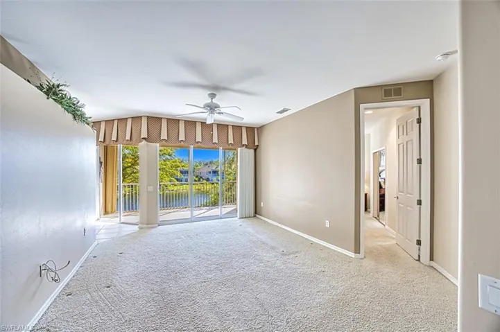Unfurnished room featuring light carpet, ceiling fan, and lofted ceiling