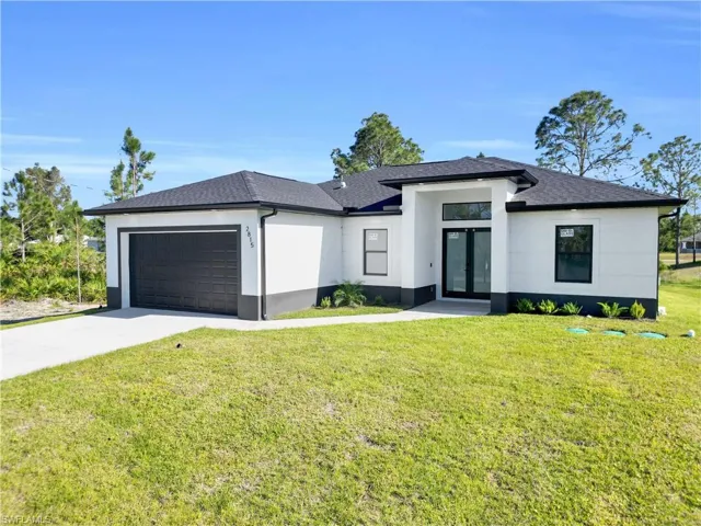 Prairie-style house with french doors, stucco siding, a garage, and concrete driveway