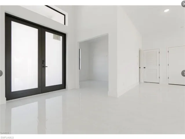 Tiled foyer featuring french doors and recessed lighting