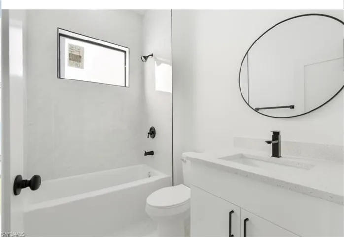 Bathroom with toilet, vanity, and shower / tub combination