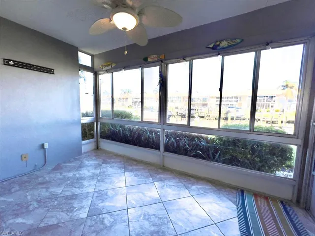 Unfurnished sunroom with ceiling fan and plenty of natural light