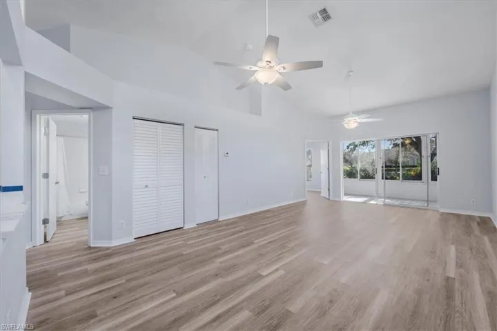 Unfurnished living room featuring light wood-style floors, high vaulted ceiling, and a ceiling fan