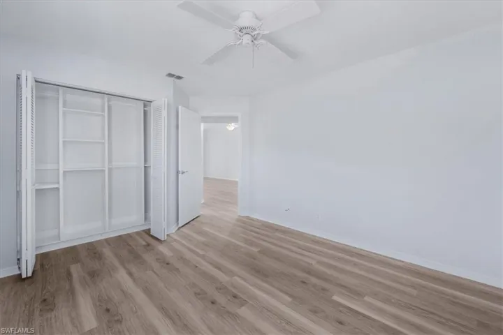 Unfurnished bedroom with light wood finished floors, a ceiling fan, and a closet