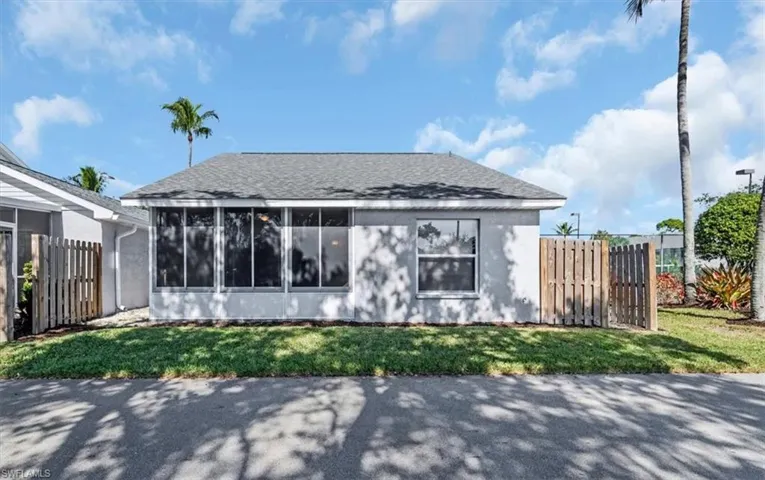 Rear view of property featuring a shingled roof and a sunroom