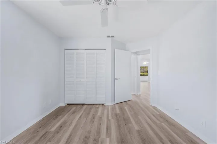 Unfurnished bedroom featuring light wood-style flooring, a closet, and a ceiling fan