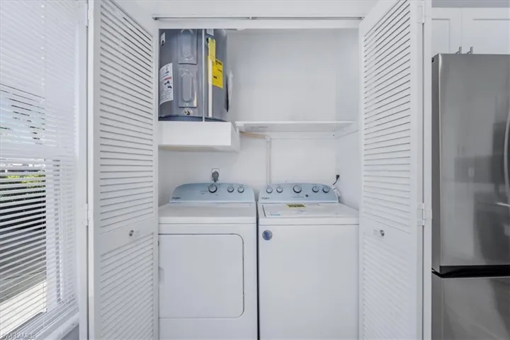 Laundry room with water heater and washer and dryer