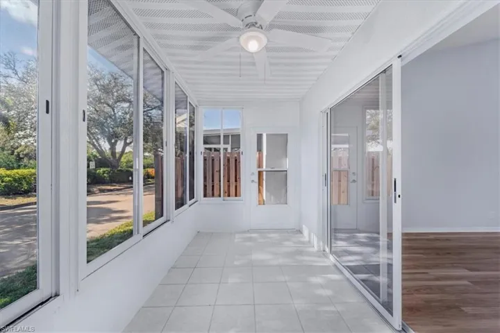 Unfurnished sunroom featuring a ceiling fan and plenty of natural light